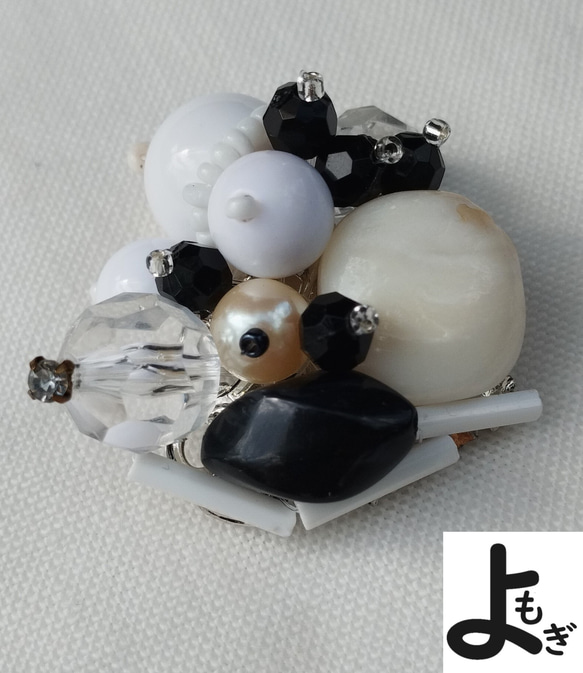 変形貝のある白と黒のブローチ 1枚目の画像