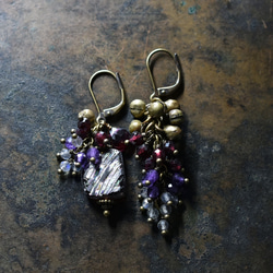 由紫色鍍銀羅馬玻璃、天然小寶石和民族鈴鐺製成的不對稱耳環。 第2張的照片