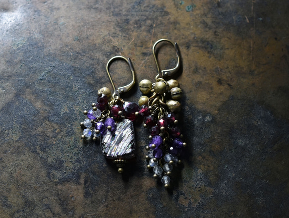 由紫色鍍銀羅馬玻璃、天然小寶石和民族鈴鐺製成的不對稱耳環。 第2張的照片