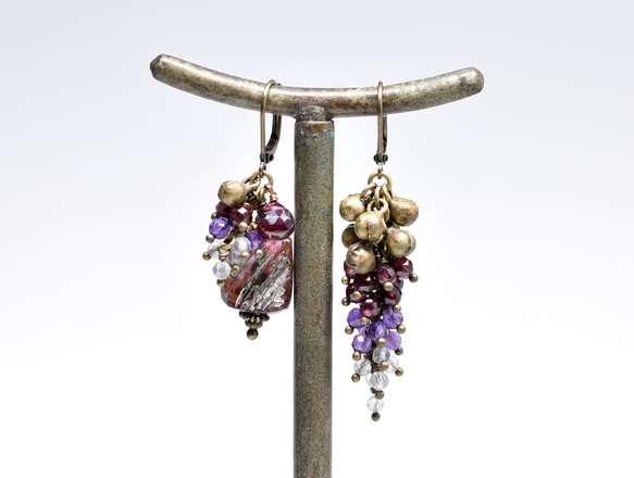 由紫色鍍銀羅馬玻璃、天然小寶石和民族鈴鐺製成的不對稱耳環。 第1張的照片