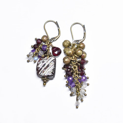 由紫色鍍銀羅馬玻璃、天然小寶石和民族鈴鐺製成的不對稱耳環。 第5張的照片