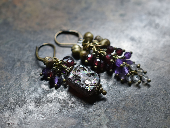 由紫色鍍銀羅馬玻璃、天然小寶石和民族鈴鐺製成的不對稱耳環。 第4張的照片