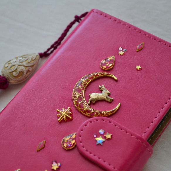 星達の輝き。手帳型スマホケース『うさぎと月のロマンティック』ぴょんと飛ぶ兎、大人可愛いピンクとゴールド☆全機種対応 1枚目の画像