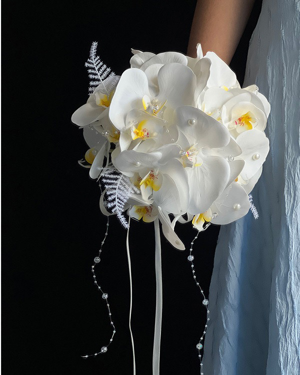 結婚式の花嫁 胡蝶蘭造花、外装ウェディングドレス、写真撮影、結婚式の花嫁の手のブーケ