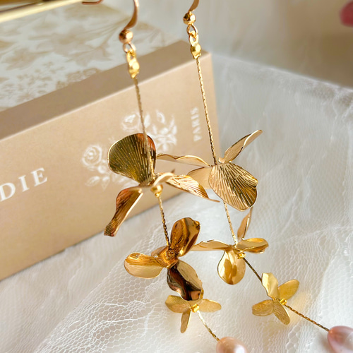 3連のゴールドフラワーとピンク色の淡水パールが揺れるピアス