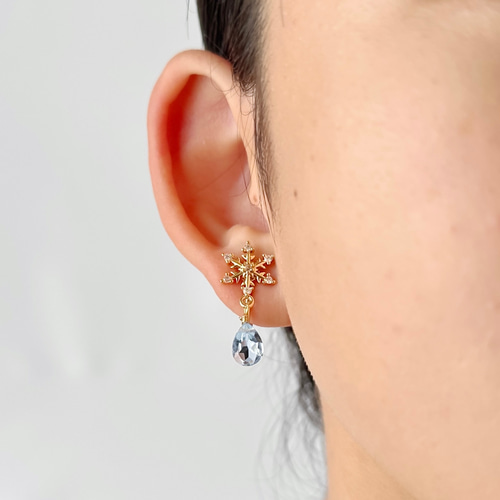 雪の結晶と揺れるクリアスカイブルートパーズのかわいいイヤリング