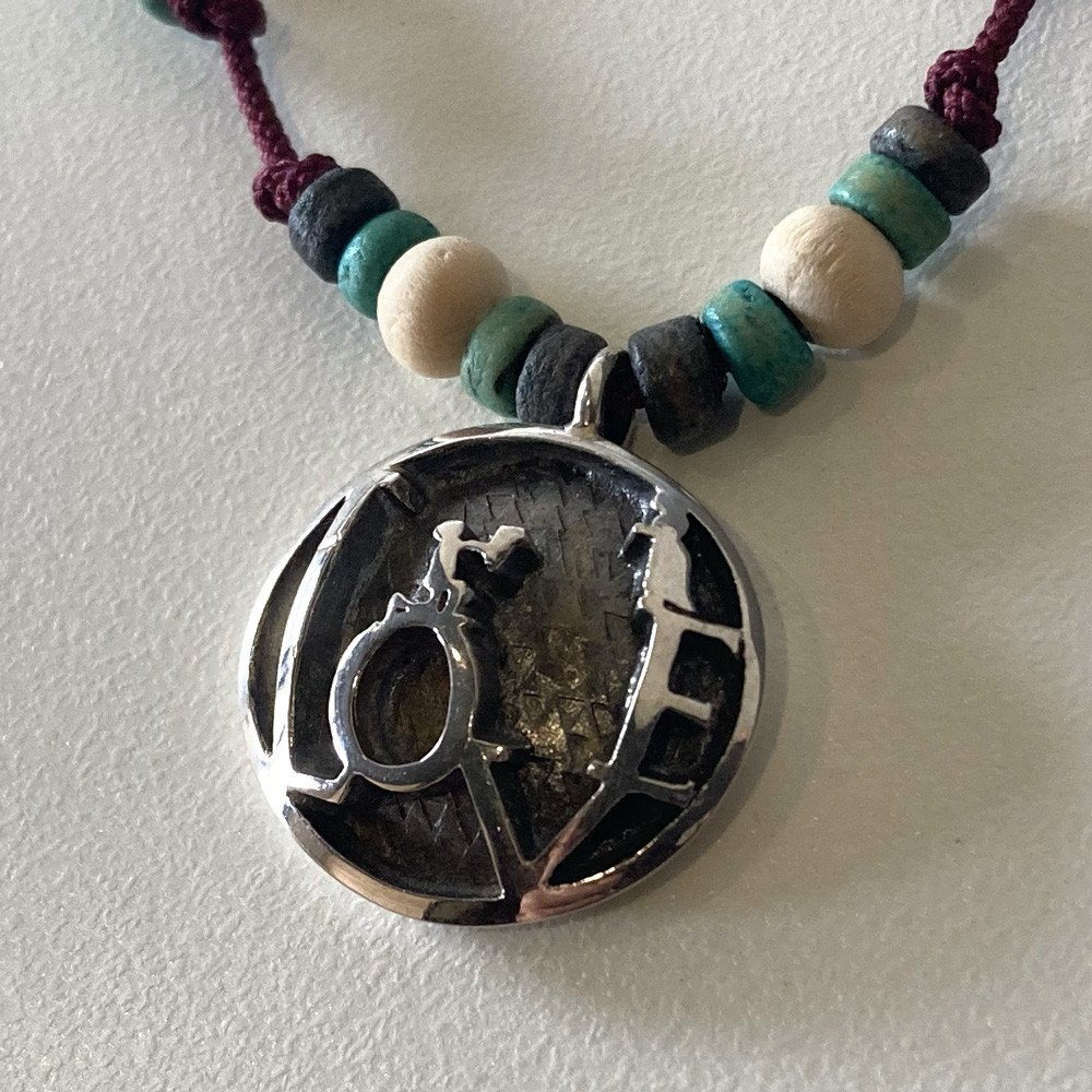 物語の一場面・花束を持ち告白するシルエットのビーズペンダント「CONFESSION COIN PENDANT」