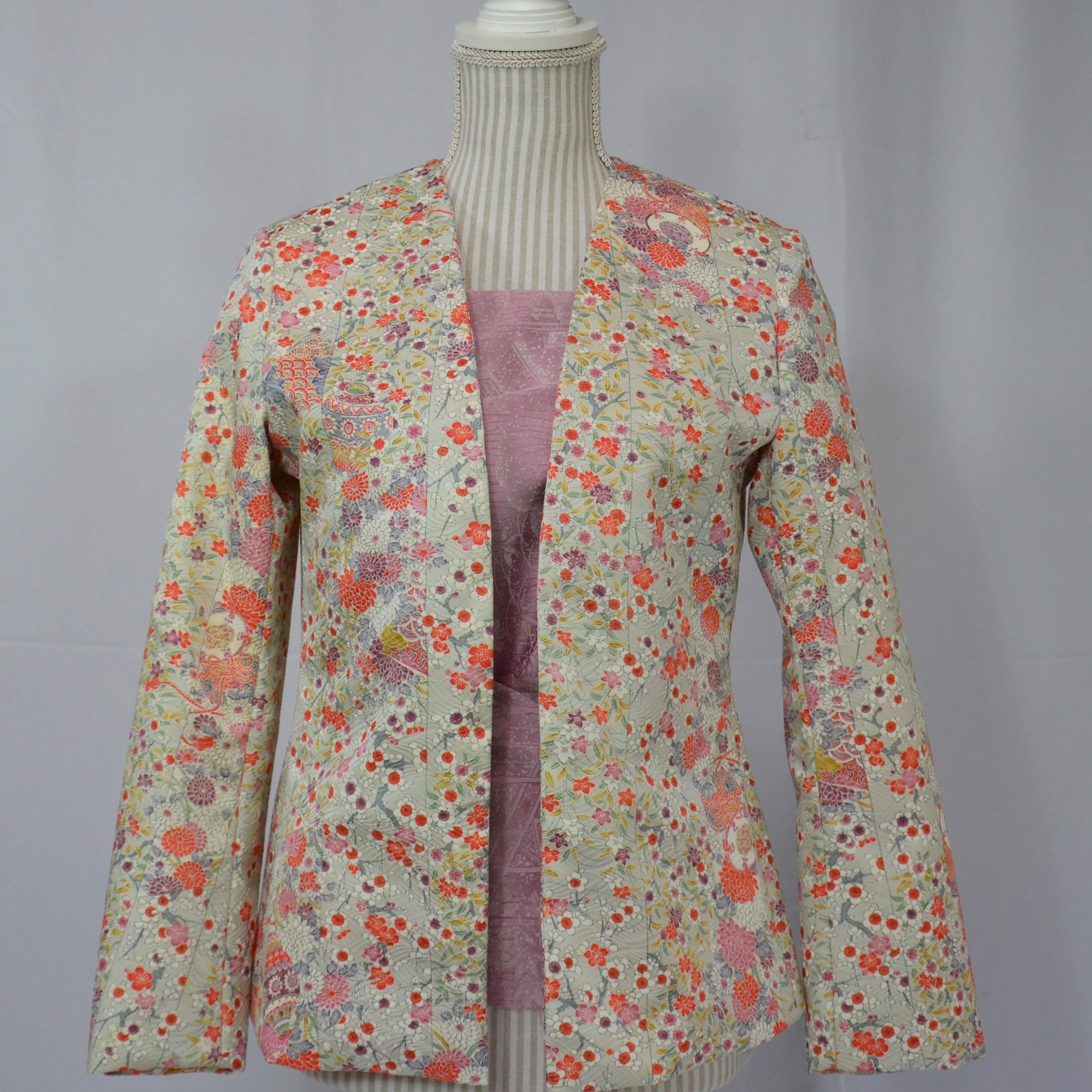 淡い萌黄色に軽やかな模様が絡み合うチャーミングなジャケット