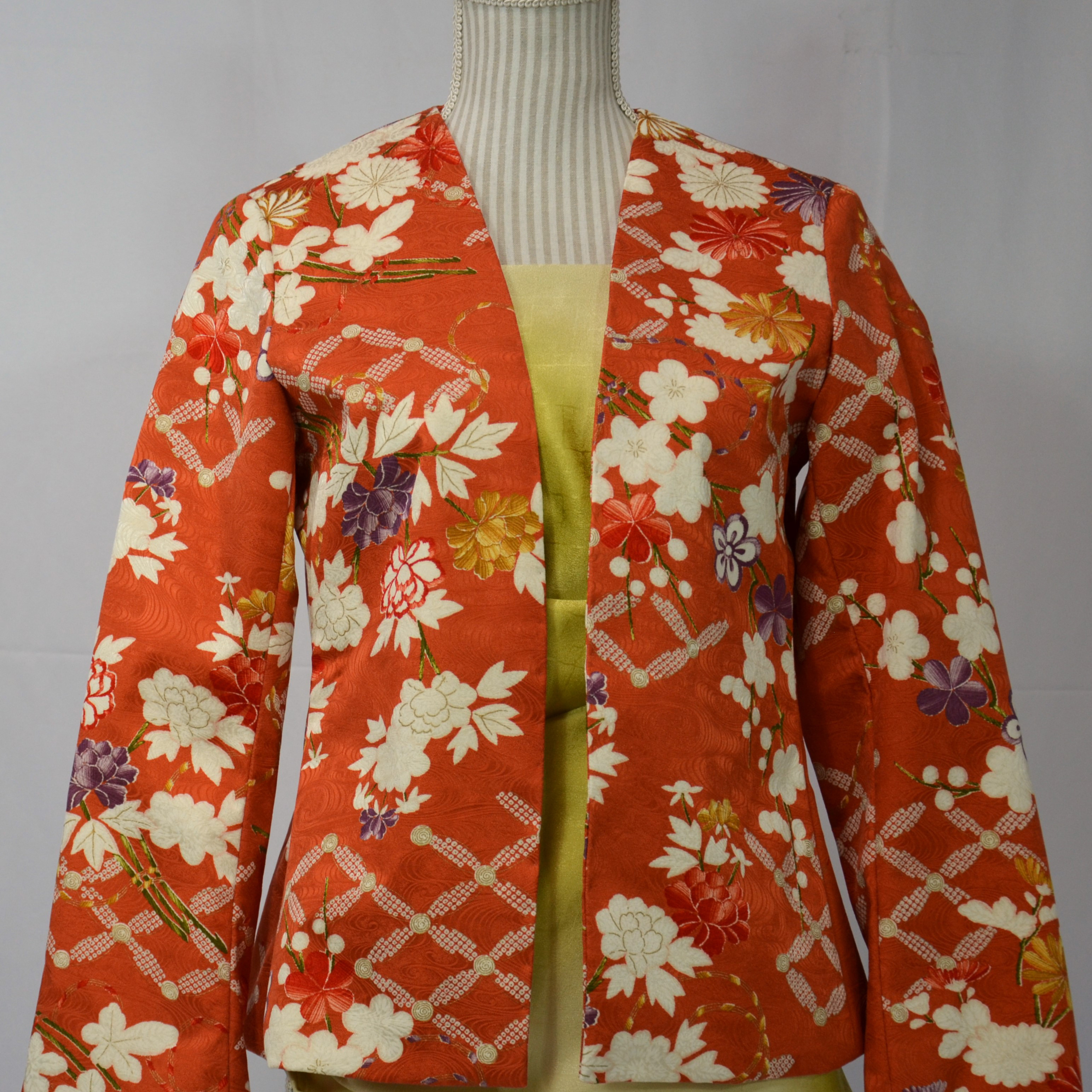 光琳水紋様に賑やかなモチーフが躍る赤煉瓦色のジャケット
