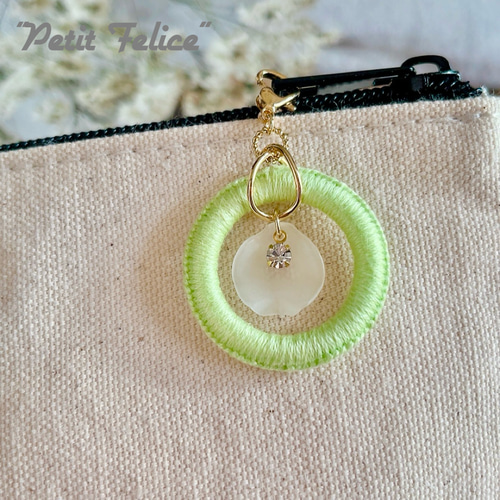 刺繍糸で編んだリングワークの中で花びらとラインストーンが