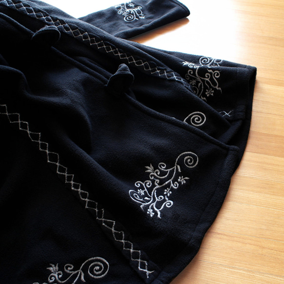 輕盈保暖 * 植物刺繡 * 大號扣環裝飾 * 大號兜帽 * 厚實抓絨布料 * 長外套 * 黑色 第12張的照片