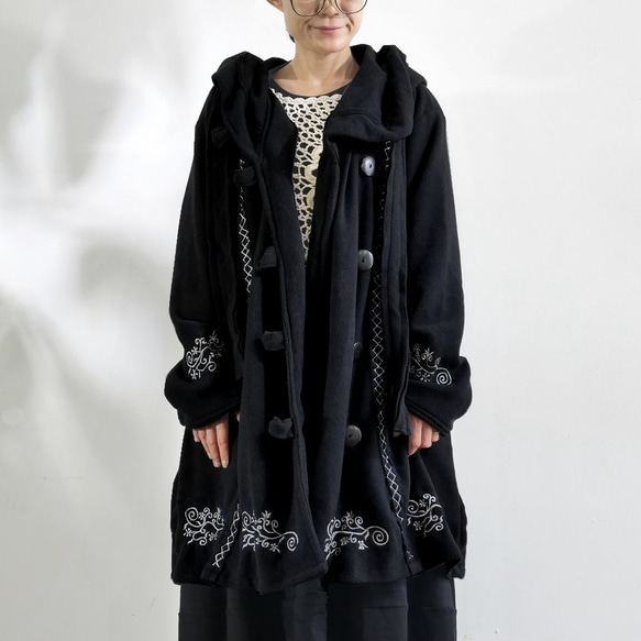 輕盈保暖 * 植物刺繡 * 大號扣環裝飾 * 大號兜帽 * 厚實抓絨布料 * 長外套 * 黑色 第5張的照片