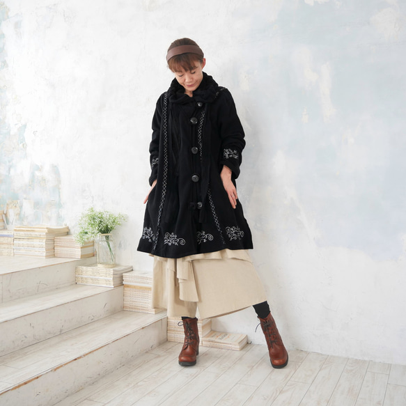 輕盈保暖 * 植物刺繡 * 大號扣環裝飾 * 大號兜帽 * 厚實抓絨布料 * 長外套 * 黑色 第2張的照片