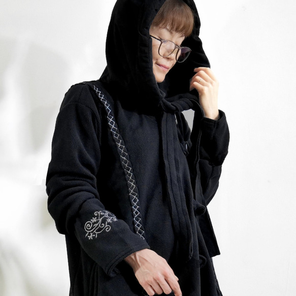 輕盈保暖 * 植物刺繡 * 大號扣環裝飾 * 大號兜帽 * 厚實抓絨布料 * 長外套 * 黑色 第9張的照片