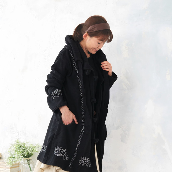 輕盈保暖 * 植物刺繡 * 大號扣環裝飾 * 大號兜帽 * 厚實抓絨布料 * 長外套 * 黑色 第4張的照片