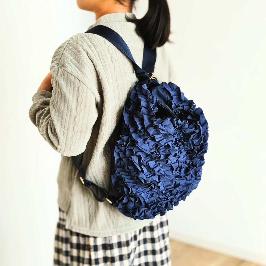 一瞬でショルダーに。紺が映える！フリルで魅せる魔法の極上リュック
