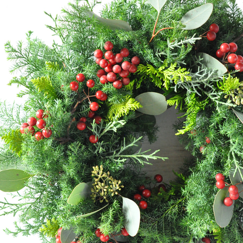 針葉樹と赤い実のクリスマスリース
