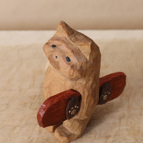 スノーボードの板を抱えて雪を待つ猫」木彫り 木製 ネコの置物（木材