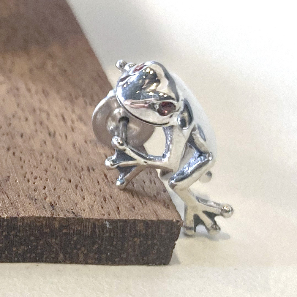 目にガーネットを留めたアカメアマカエルが耳にしがみつくシルバーピアス「FROG PIERCE custom」
