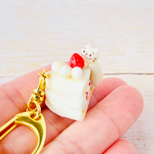 ネコちゃんがいちごショートケーキの上でうっとり幸せフェイクスイーツ