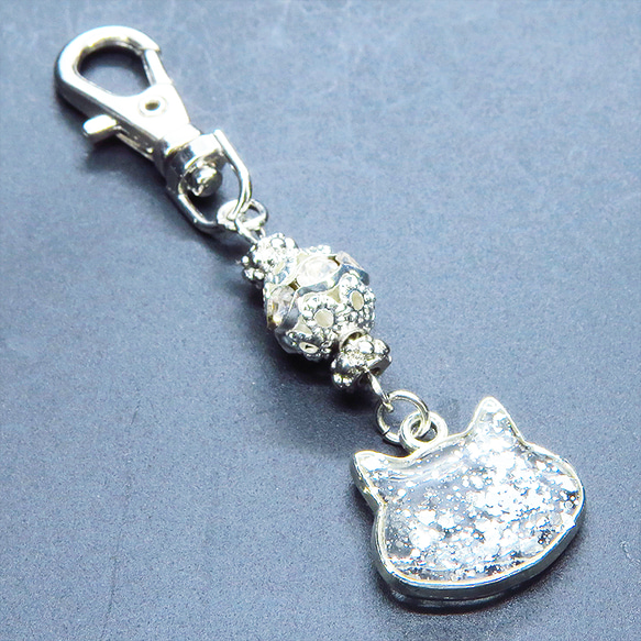 シルバーカラー 猫フェイスモチーフのクリアカラーレジンのキーホルダー ラインストーン入りメタルビーズ 金具変更可 1枚目の画像