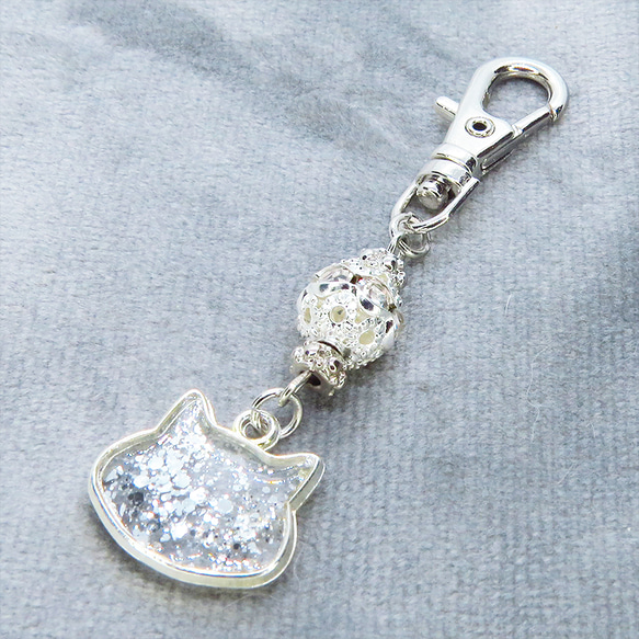 シルバーカラー 猫フェイスモチーフのクリアカラーレジンのキーホルダー ラインストーン入りメタルビーズ 金具変更可 2枚目の画像