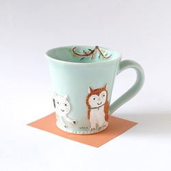 イヌさんとネコさん、道でバッタリ会う。　ゆっくりティータイム（イヌとネコと小鳥）マグカップ　磁器 1枚目の画像