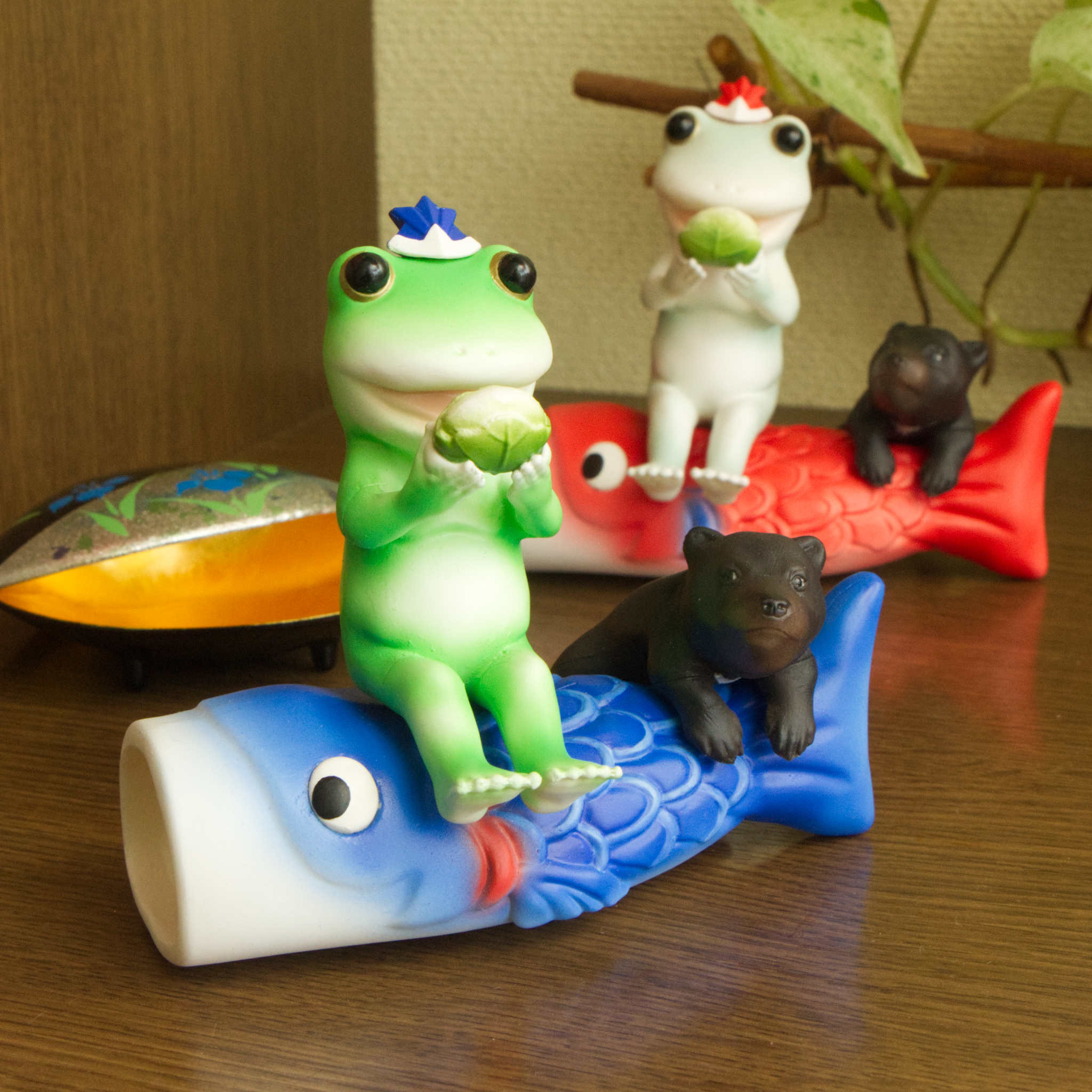 端午の節句で鯉のぼりに座って柏餅を食べようとしていたらこぐまに見つかってしまったカエル