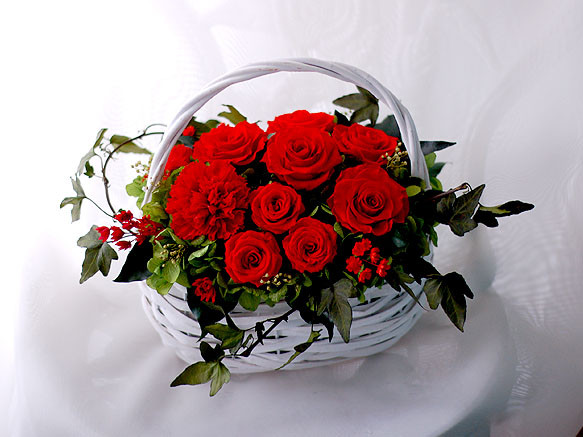 白いバスケットを彩るエレガントなレッドローズのアレンジ