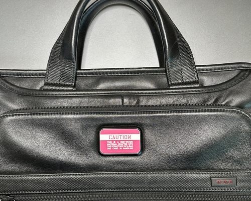 ◇ TUMIバッグ カスタムプレート CAUTION ピンクxホワイト 30x50mm