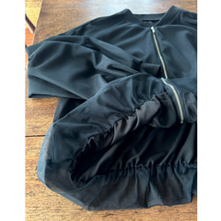 這款輕盈蓬鬆的透明拉鍊外套，擁有寬鬆的袖子和精緻的立體剪裁。尺寸完美，展現優雅氣質。輕盈透氣，不易起皺。適合所有季節穿著。 第12張的照片