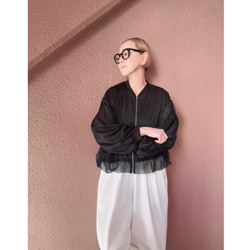 這款輕盈蓬鬆的透明拉鍊外套，擁有寬鬆的袖子和精緻的立體剪裁。尺寸完美，展現優雅氣質。輕盈透氣，不易起皺。適合所有季節穿著。 第13張的照片