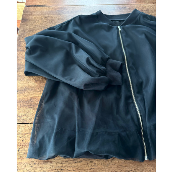 這款輕盈蓬鬆的透明拉鍊外套，擁有寬鬆的袖子和精緻的立體剪裁。尺寸完美，展現優雅氣質。輕盈透氣，不易起皺。適合所有季節穿著。 第11張的照片