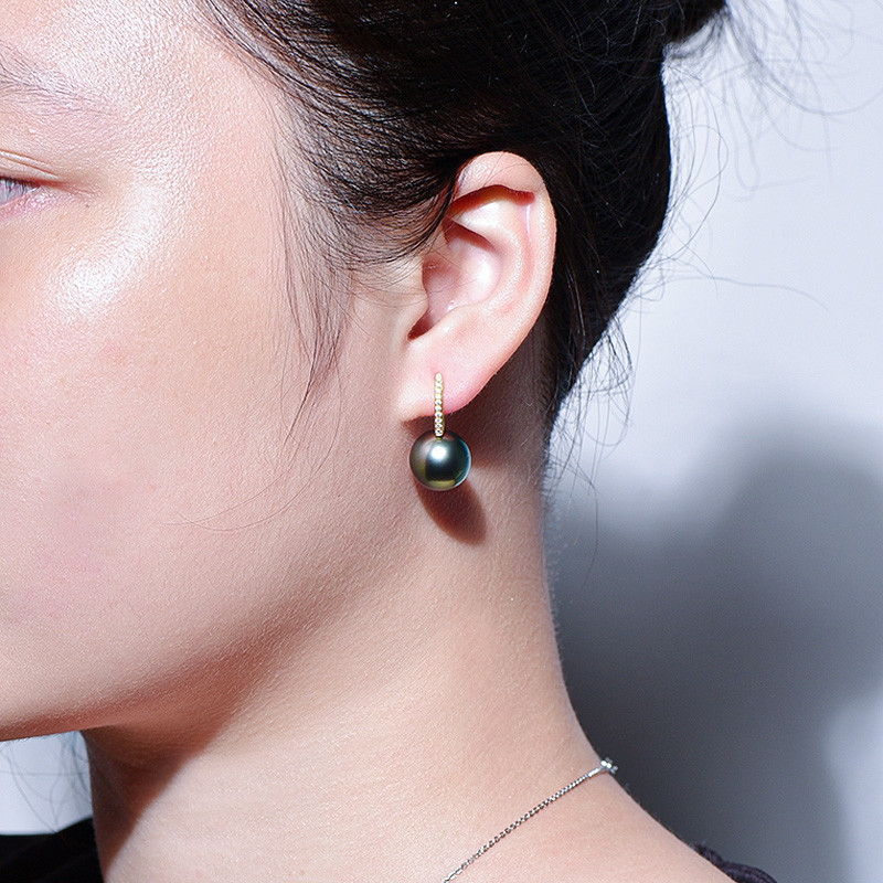 18Kゴールド製、12～13mmタヒチ産ブラックパールのルミナイヤリング。ピーコックグリーンの輝きを放つバケットデザイン。クラシ