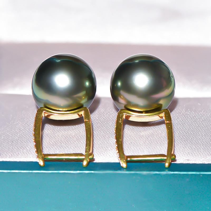 18Kゴールド製、12～13mmタヒチ産ブラックパールのルミナイヤリング。ピーコックグリーンの輝きを放つバケットデザイン。クラシ