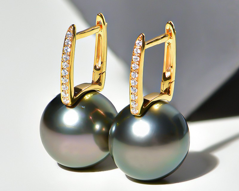 18Kゴールド製、12～13mmタヒチ産ブラックパールのルミナイヤリング。ピーコックグリーンの輝きを放つバケットデザイン。クラシ