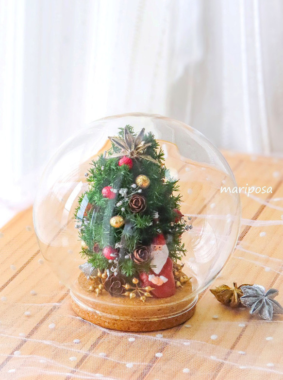 ドームグラスコルクビンの中のクリスマスツリーとサンタの妖精