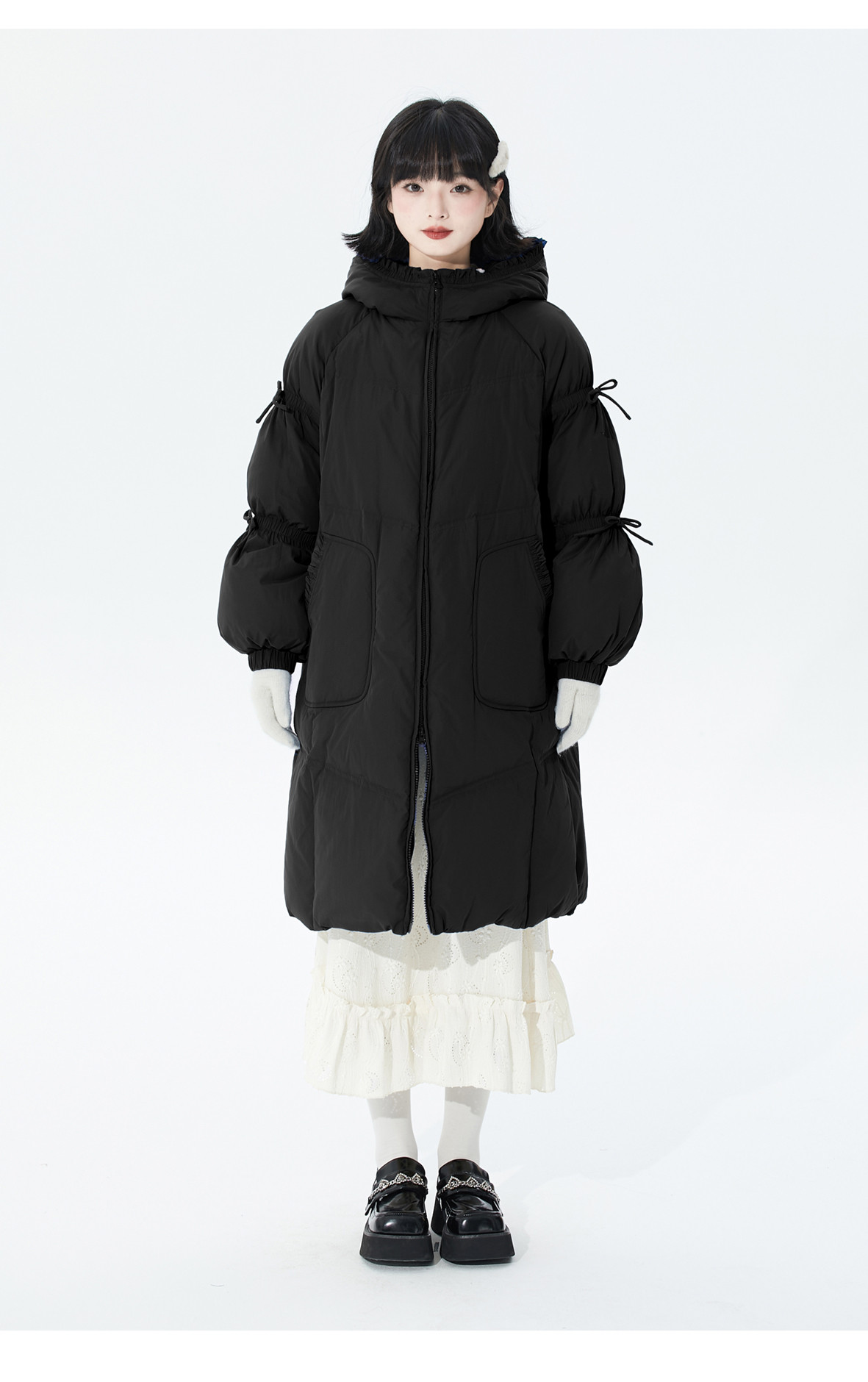 冬の白いアヒルの綿毛と厚い連帽の黒いダウンジャケット