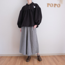 這款黑色法蘭絨小襯衫，領口和袖口都經過精心設計，非常適合秋冬季節穿著。 第4張的照片