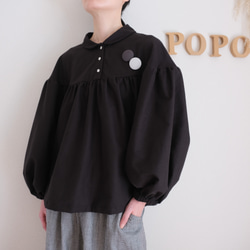 這款黑色法蘭絨小襯衫，領口和袖口都經過精心設計，非常適合秋冬季節穿著。 第2張的照片