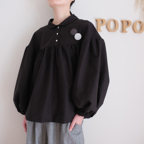 這款黑色法蘭絨小襯衫，領口和袖口都經過精心設計，非常適合秋冬季節穿著。 第2張的照片