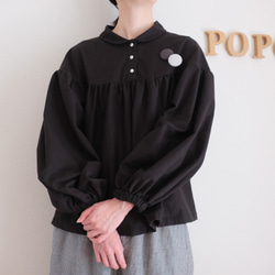 這款黑色法蘭絨小襯衫，領口和袖口都經過精心設計，非常適合秋冬季節穿著。 第1張的照片