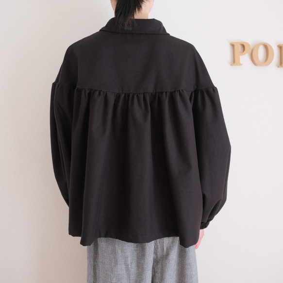 這款黑色法蘭絨小襯衫，領口和袖口都經過精心設計，非常適合秋冬季節穿著。 第5張的照片