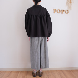 這款黑色法蘭絨小襯衫，領口和袖口都經過精心設計，非常適合秋冬季節穿著。 第13張的照片