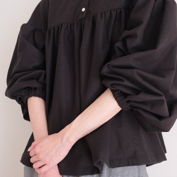 這款黑色法蘭絨小襯衫，領口和袖口都經過精心設計，非常適合秋冬季節穿著。 第8張的照片