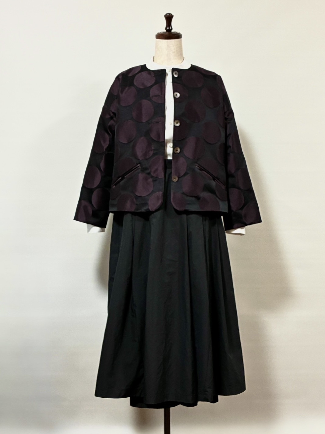 黒地にあずき色の月が浮かんだショートジャケット。ブラウスやニットと組み合わせて。