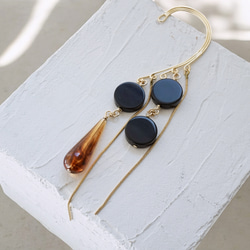 這款「點點」托特包，精緻優雅，足以媲美外套。包身飾有同色系吊墜和圓形瑪瑙耳鉤。 第4張的照片