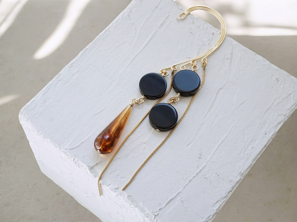 這款「點點」托特包，精緻優雅，足以媲美外套。包身飾有同色系吊墜和圓形瑪瑙耳鉤。 第4張的照片