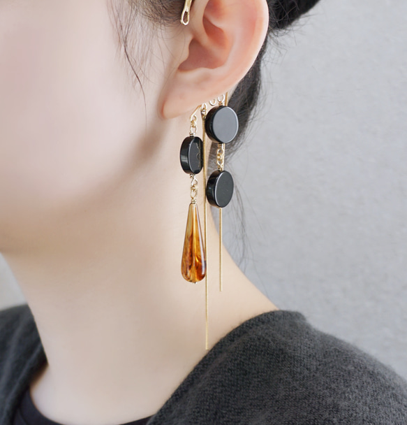 這款「點點」托特包，精緻優雅，足以媲美外套。包身飾有同色系吊墜和圓形瑪瑙耳鉤。 第2張的照片