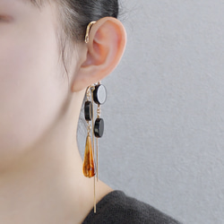 這款「點點」托特包，精緻優雅，足以媲美外套。包身飾有同色系吊墜和圓形瑪瑙耳鉤。 第3張的照片